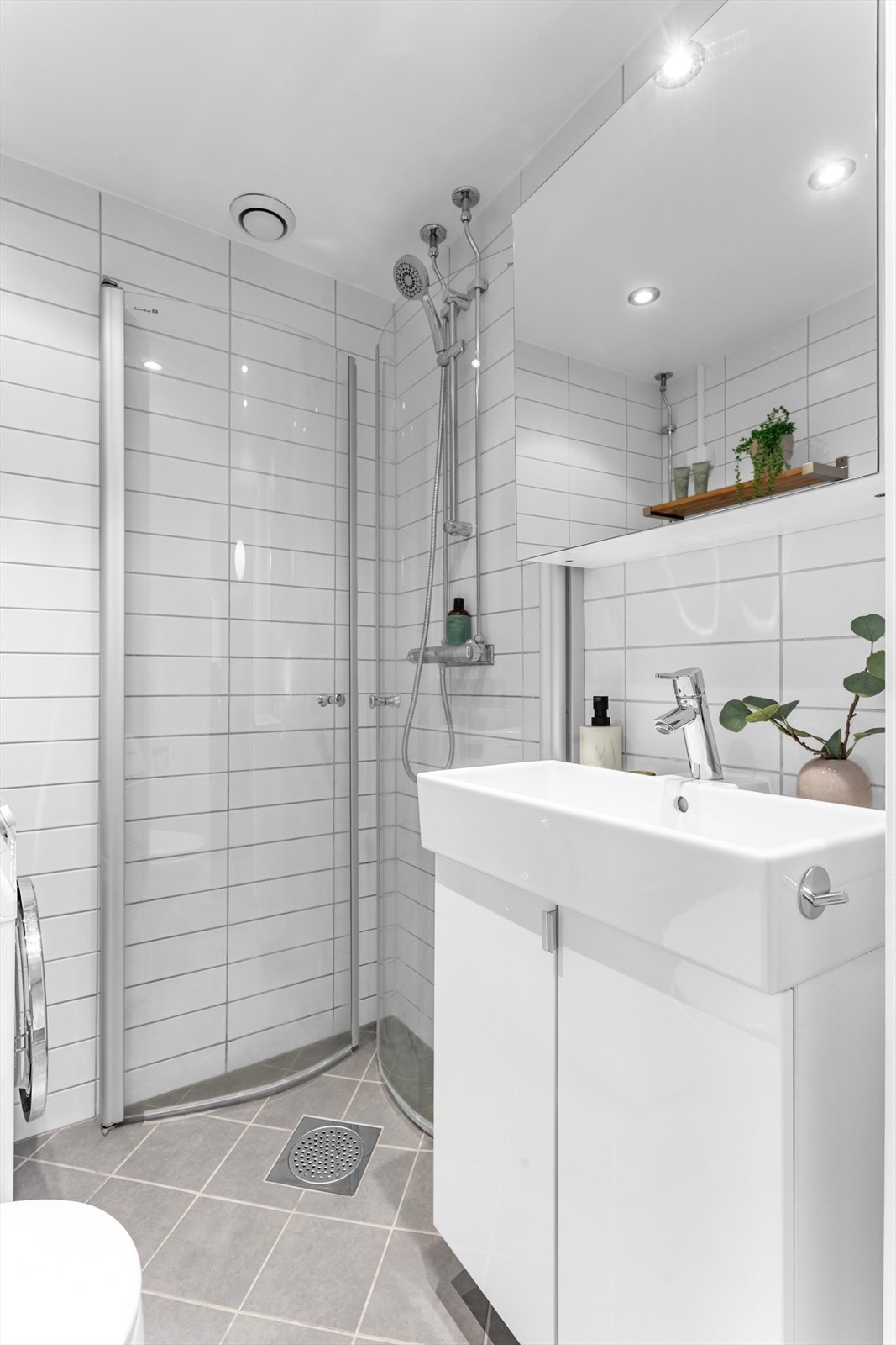 Badet er videre utstyrt med vegghengt toalett og dusjdører i herdet glass. Justerbare dusjdører er satt inn for å utnytte plassen maksimalt. Galleribilde