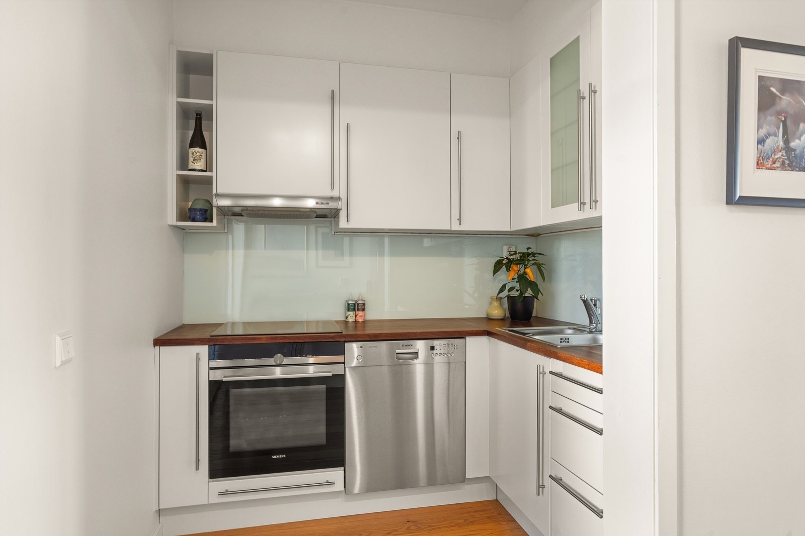 Moderne Norema-kjøkken med rikelig skap- og benkeplass. Innredet med glatte fronter og heltre benkeplate med nedfelt oppvaskkum. Galleribilde