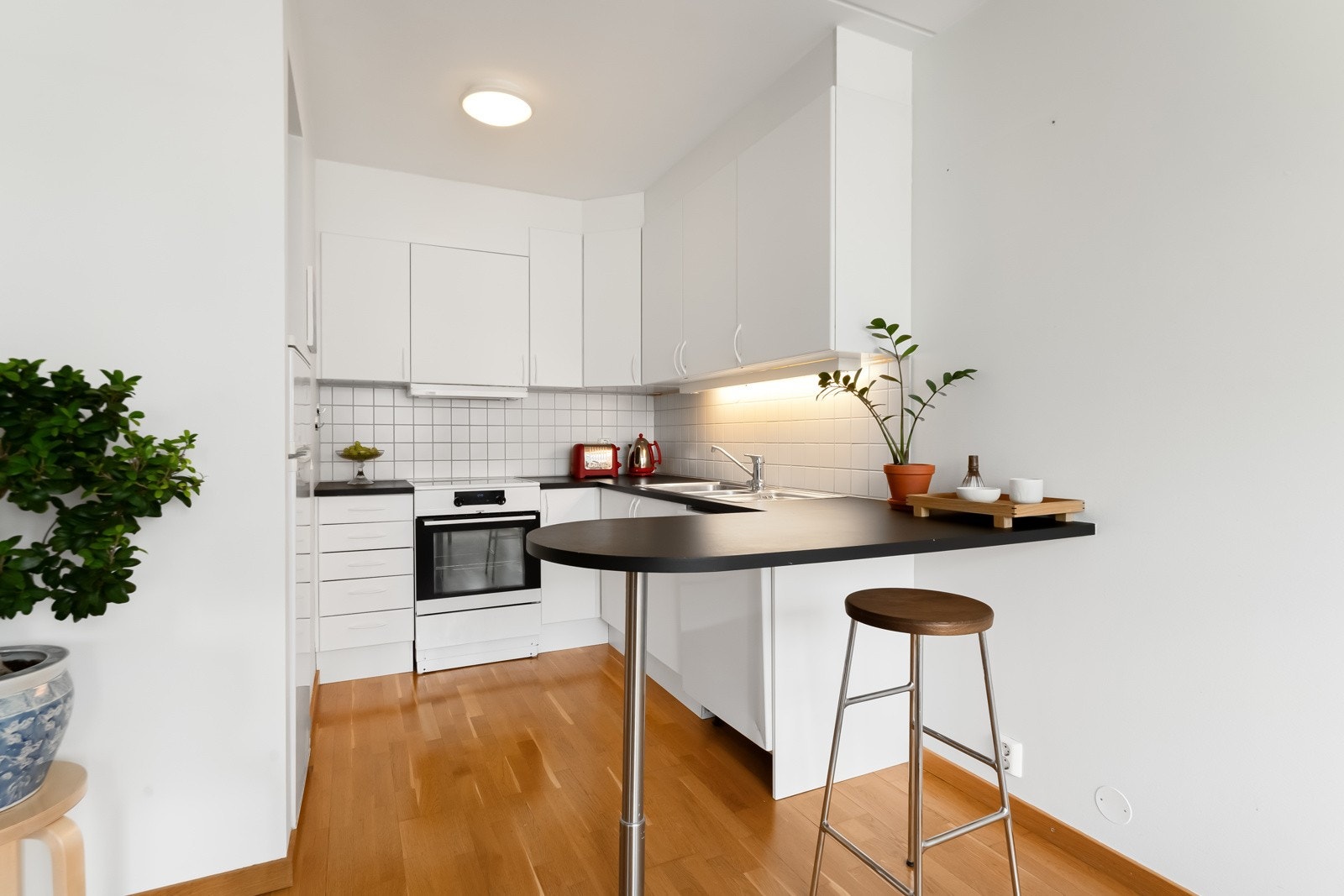 Takhøy kjøkkeninnredning i egen sone med slette fronter og laminat benkeplate med halvøy. Galleribilde