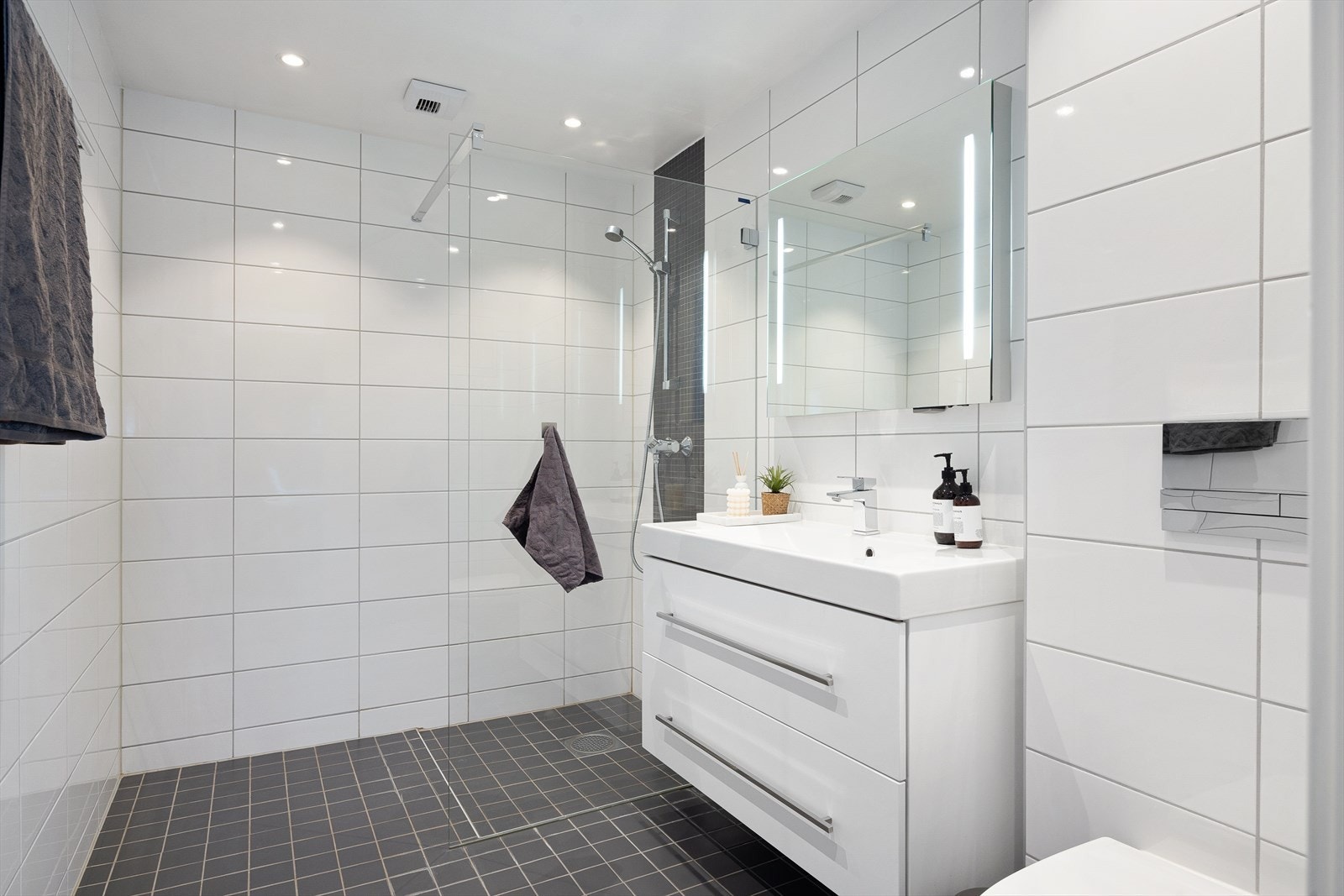 Pent flislagt baderom med gulvvarme og downlights i himlingen. Galleribilde