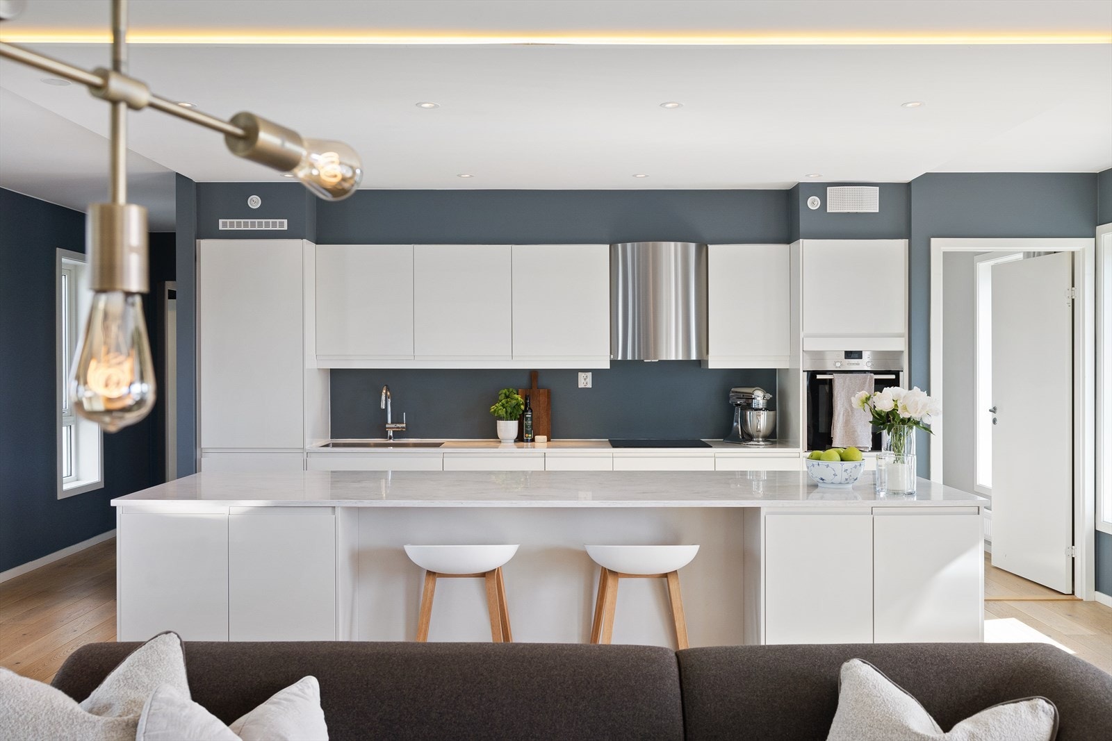 Kjøkkenet har glatte fronter og en slitesterk Corian benkeplate med nedfelt oppvaskkum og ettgreps svingbart blandebatteri for praktisk bruk. Galleribilde