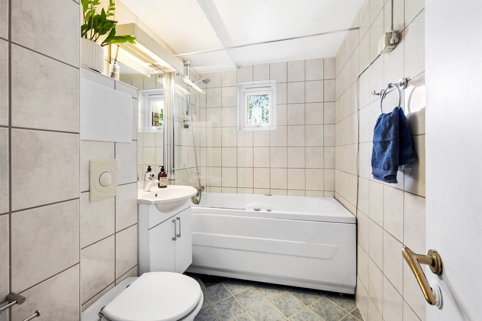 Badet er pent flislagt på gulv og vegger med varme i gulvet. Badet har klosett og badekar. Galleribilde