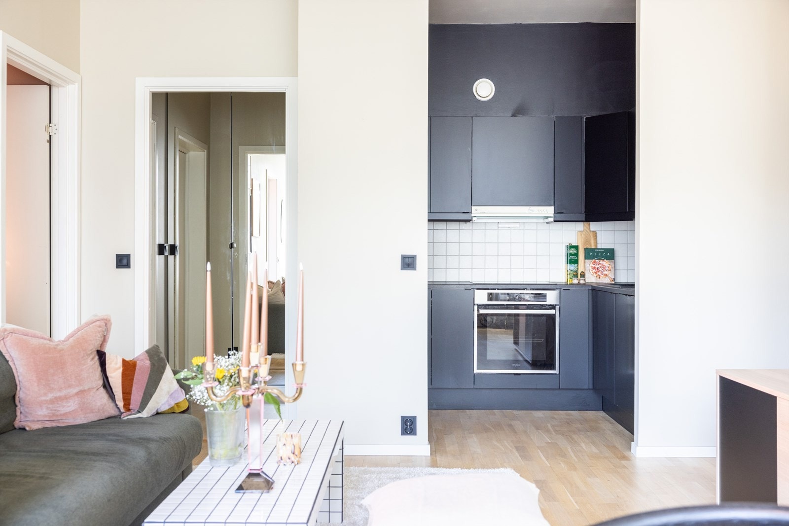 - Kjøkkeninnredning med glatte fronter, laminat benkeplate med nedfelt vask og fliser og belysning over benkeplate - Galleribilde