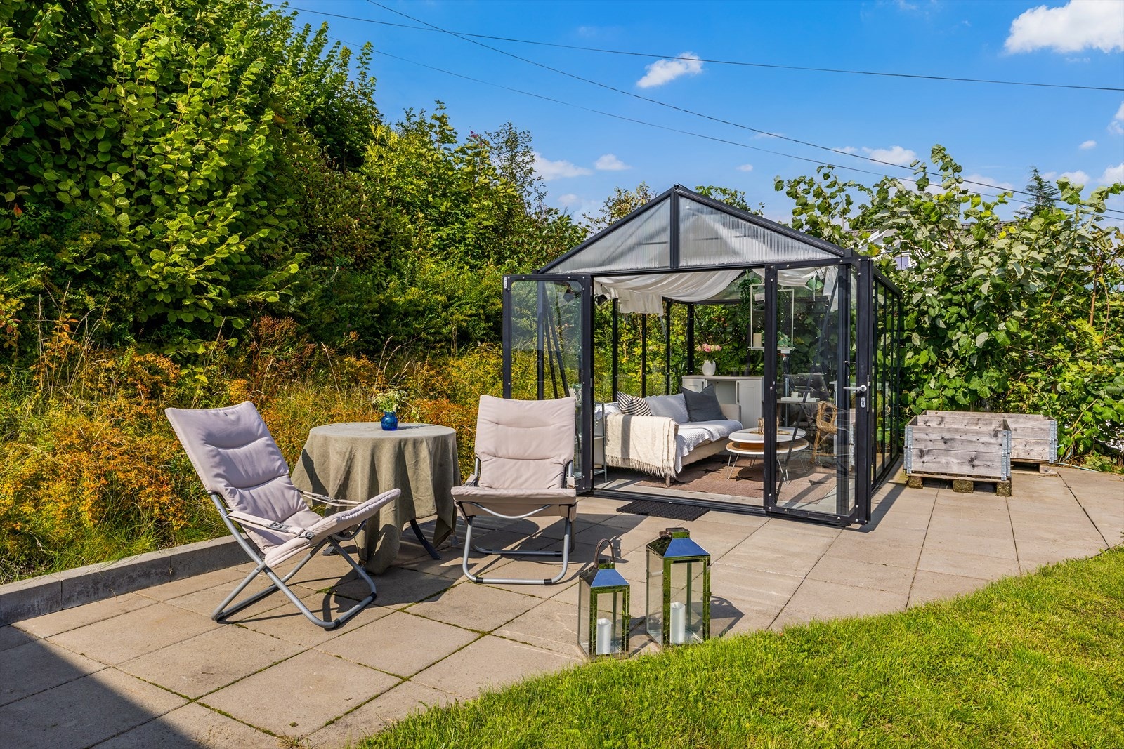 Øverst på tomten, helt mot vest, er det et hellelagt platå med moderne drivhus. Galleribilde