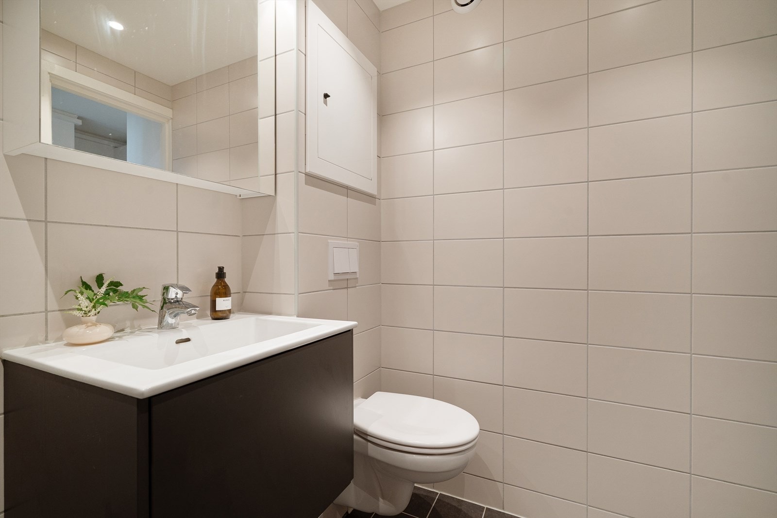 Stilrent servantskap i sort, overskap med speilfronter og belysning. Veggfestet wc. Galleribilde