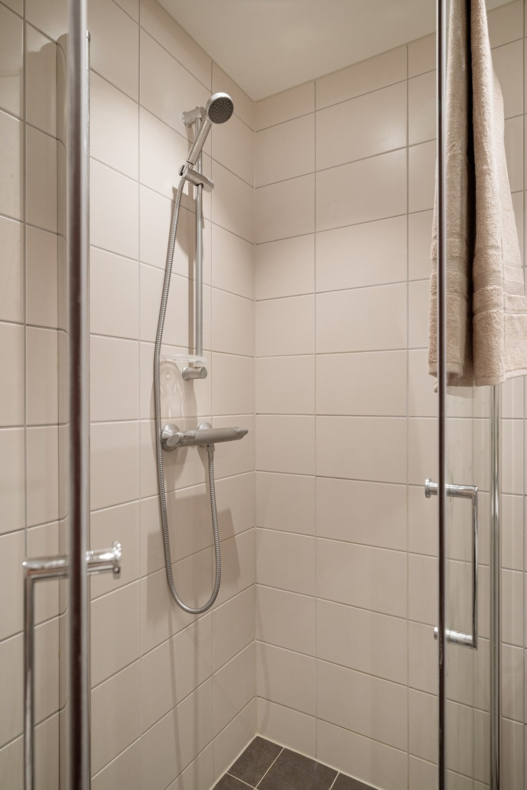 Romslig dusjnisje med dører i herdet glass. Opplegg for vaskemaskin og gulvvarme. Galleribilde