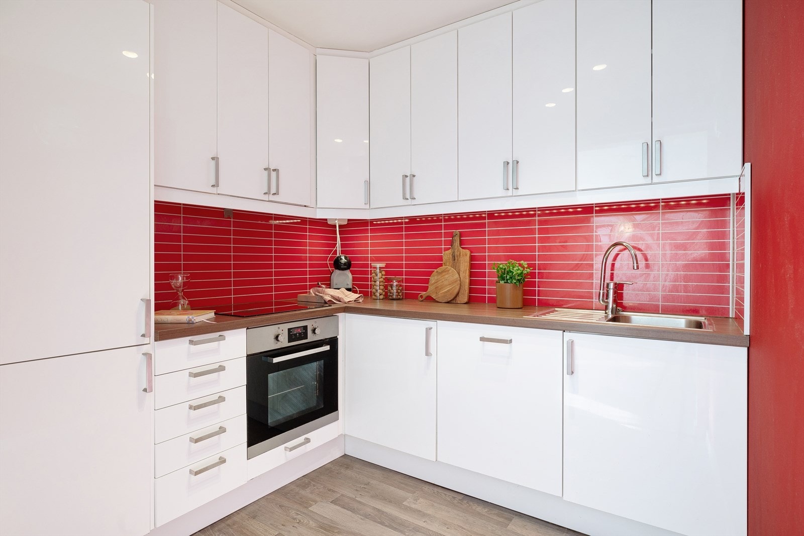 Kjøkkenet fremstår lekkert og stilrent med glatte, hvite fronter og godt med skap- og benkeplass. Galleribilde