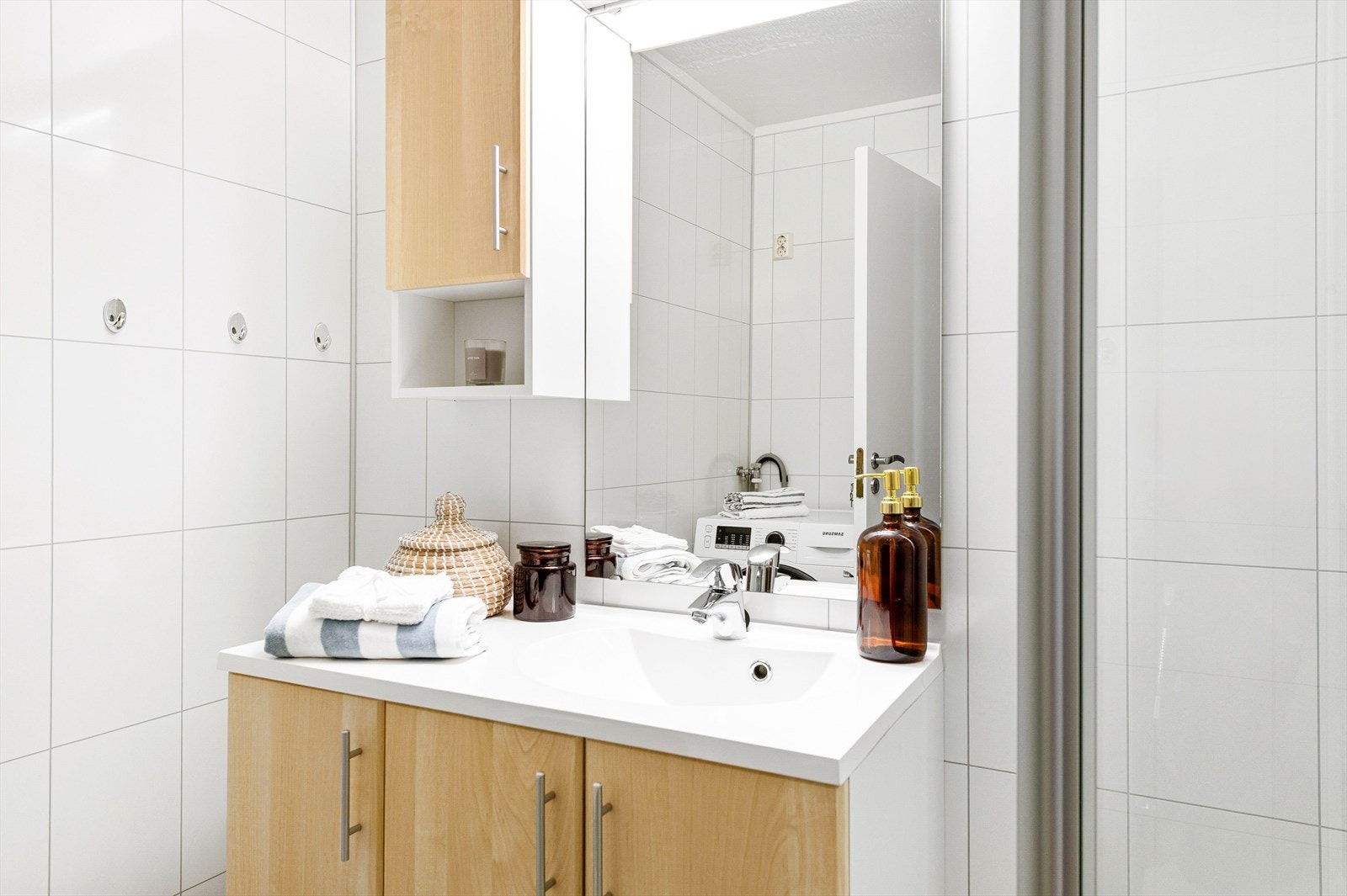 Innredning under heldekkende servant, overskap og speil med belysning. Galleribilde