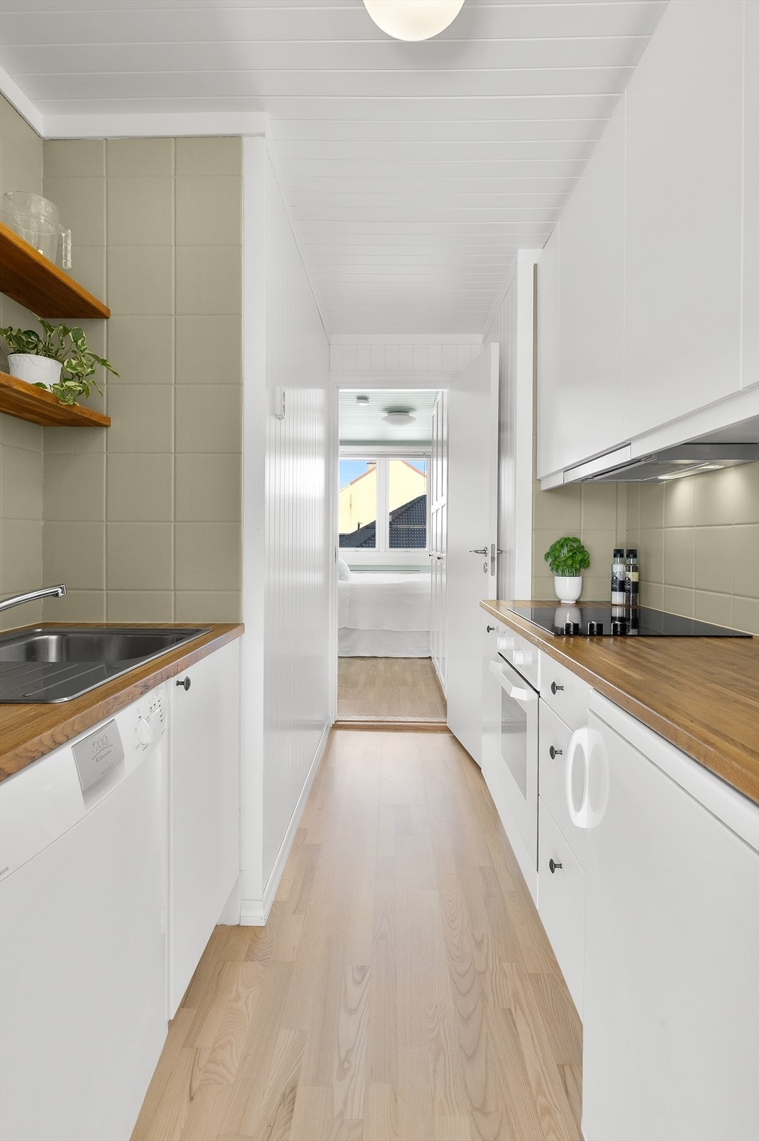 Kjøkkeninnredningen består av skap med glatte fronter, benkeplate i heltre med oppvaskkum og integrerte hvitevarer som platetopp og stekeovn. Galleribilde