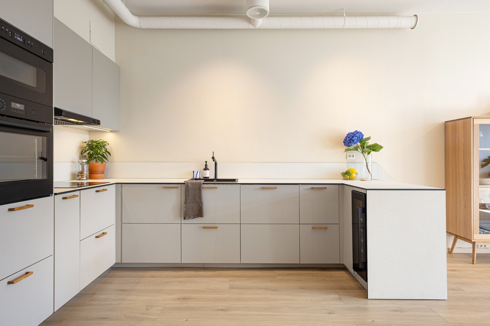 Kjøkkenet har pene fronter med håndtak i heltre eik, benkeplate av kompaktlaminat, nedsenket oppvaskkum med ett-greps armatur, i tillegg til overskapsbelysning og stikkontakter over benkeplate. Galleribilde