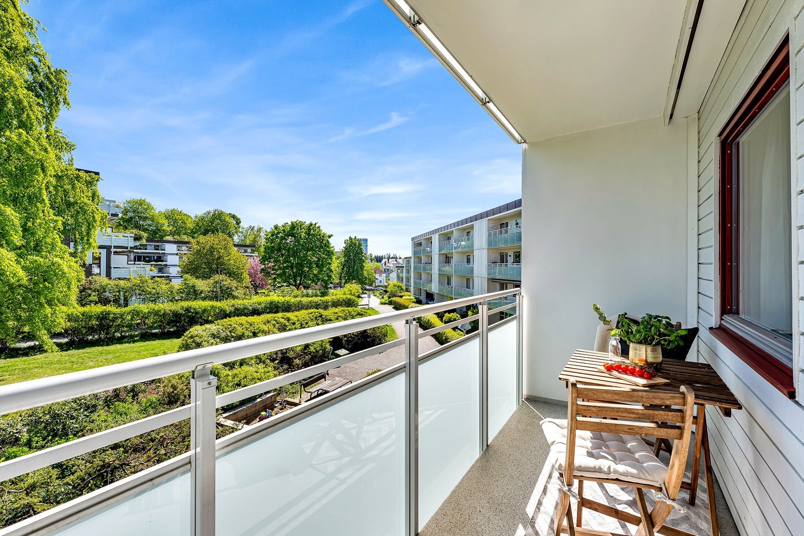 Balkongen tilhørende hovedsoverommet er utstyrt med et glassrekkverk med frostet glass, som gir en følelse av privatliv i frodige omgivelser Galleribilde