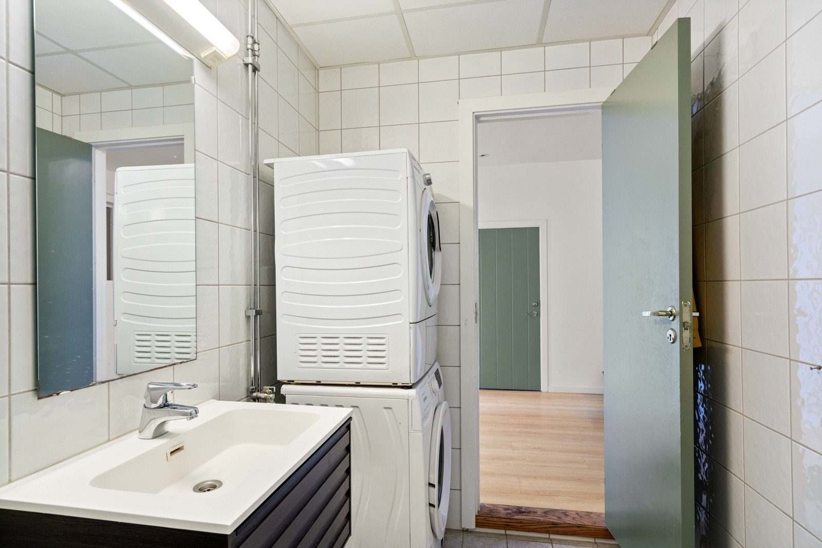 Flislagt gulv med gulvvarme, servant med skuffer under for oppbevaring og gulvstående toalett. Galleribilde