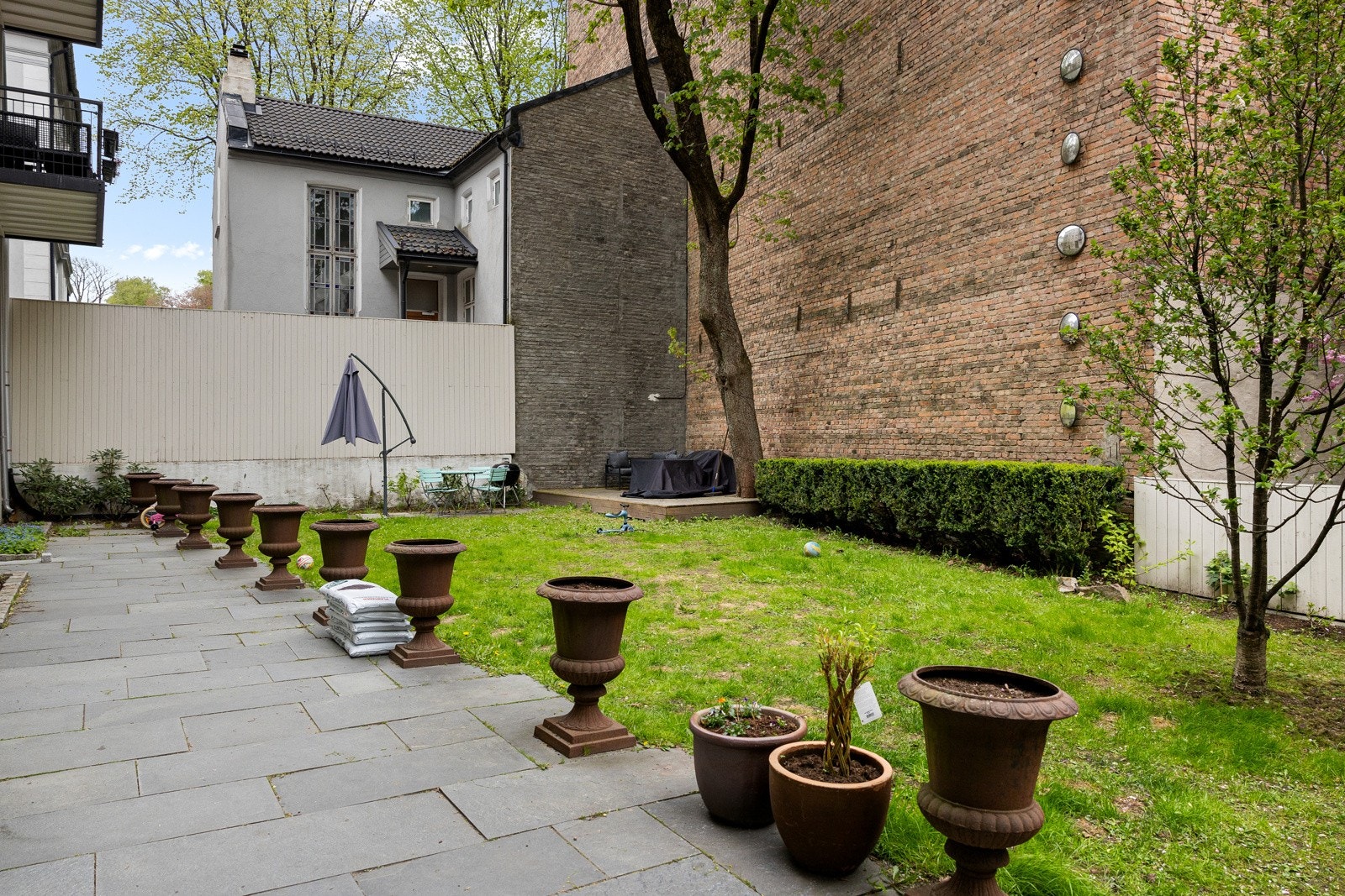 Opparbeidet gårdsrom med velstelte grøntområder Galleribilde