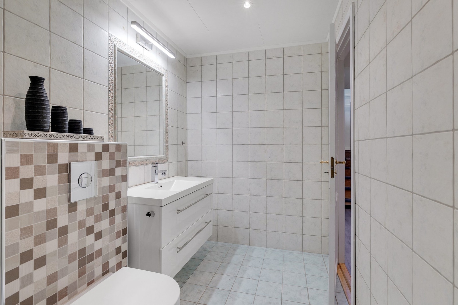 Badet har stort, vegghengt servantskap, dusjkabinett og veggmontert toalett Galleribilde