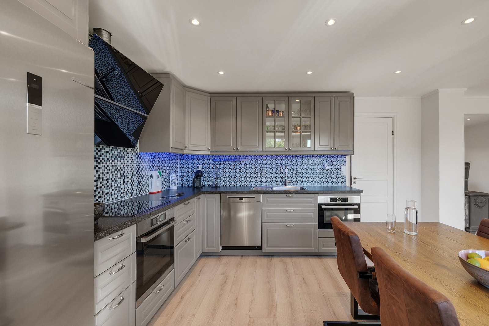 Meget funksjonelt kjøkken med integrerte hvitevarer og plass til både frittstående kjøle- og fryseskap Galleribilde