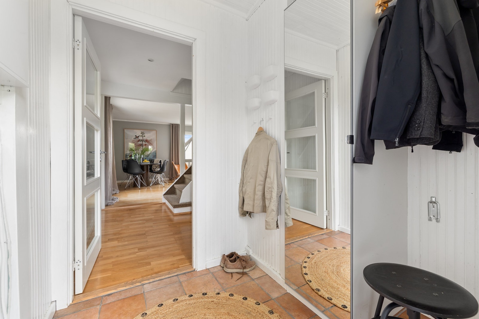 Innbydende entré med hvitmalte veggflater og terrakottafliser på gulv Galleribilde