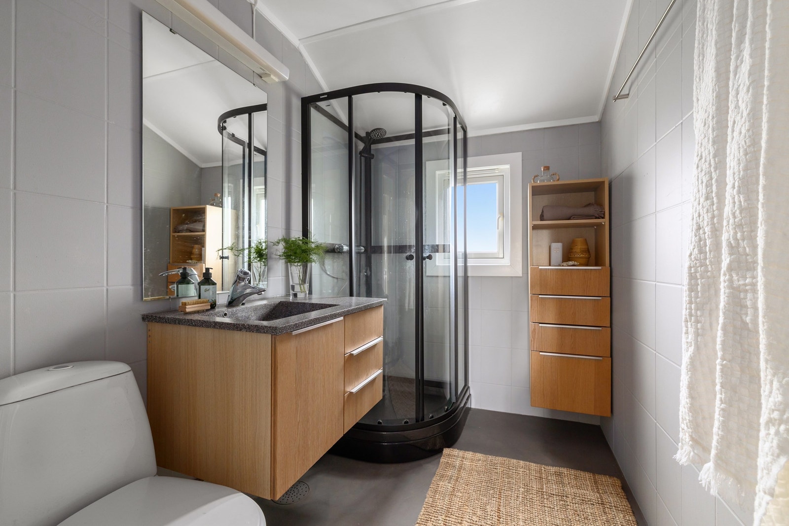 Baderom med flislagte veggflater og mikrosement på gulv med varmekabler under Galleribilde