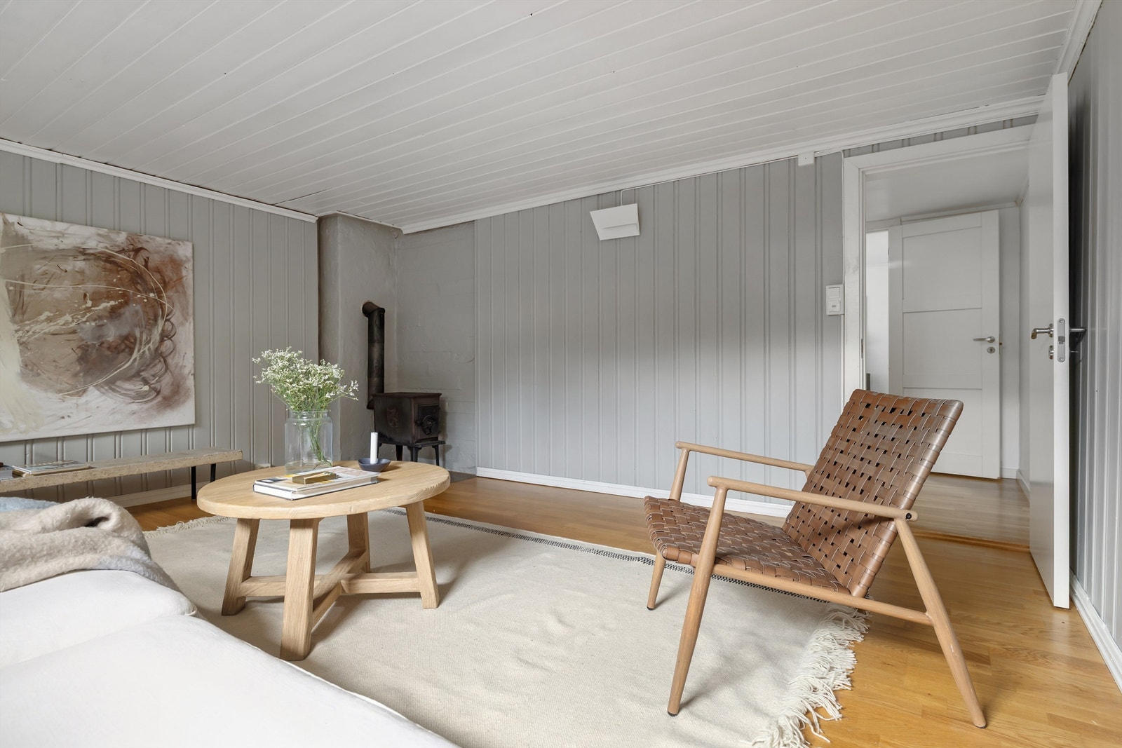 Kjelleren blir brukt som en lun og romslig kjellerstue med peisovn og varmekabler i gulv Galleribilde