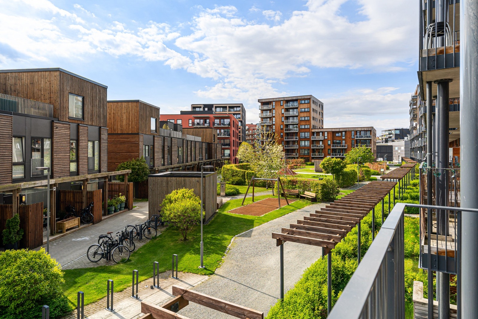 Fra balkongen har du oversikt over sameiets rolige fellesområde, som på sommerhalvåret fremstår som både frodig og velholdt. Galleribilde