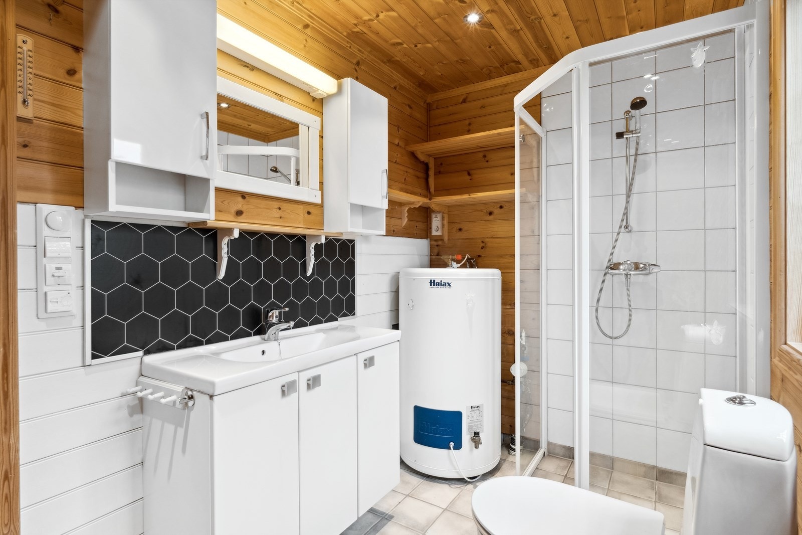 Badet er fra 2005. Fliser på gulv og vegg ved dusj. Varmekabler i gulv. Badet er utstyrt med vask i porselen med ettgrepsarmatur, fastmonterte dusjdører, dusjarmatur på vegg i dusjsonen, gulvmontert toalett, og 200L varmtvannsbreder Galleribilde