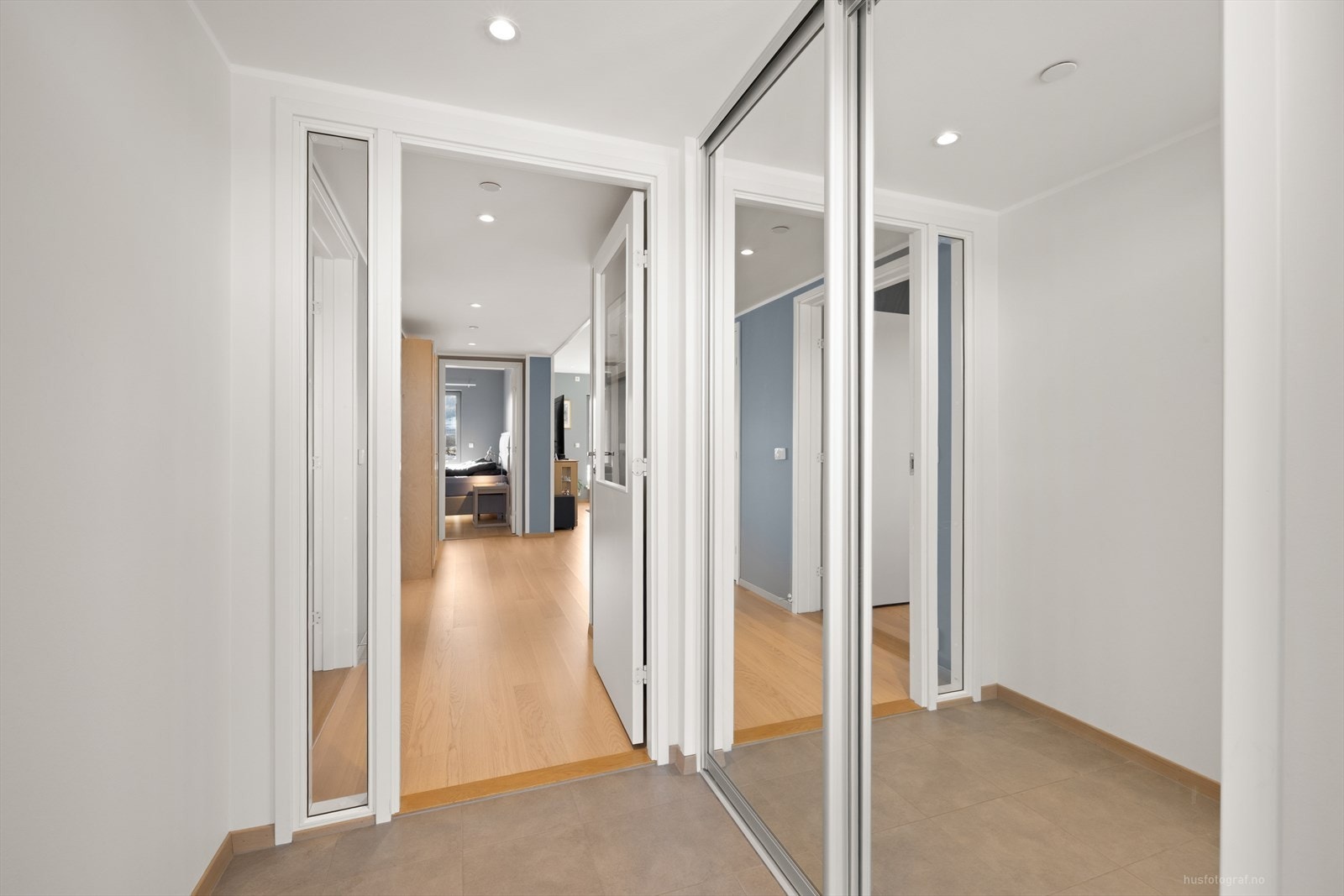 Leiligheten har en lys entré med fliser på gulv, gulvvarme og en romslig skyvedørsgarderobe. Galleribilde