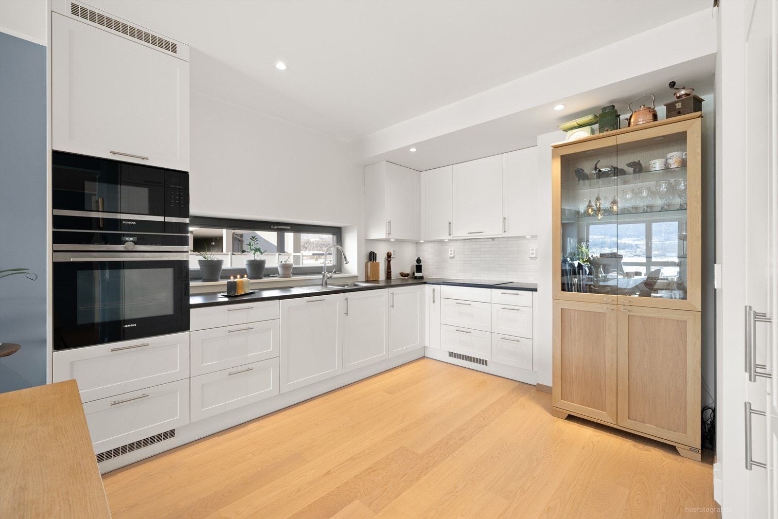 Kjøkkenet byr på integrerte hvitevarer samt rikelig med skap-, skuff- og benkeplass. Galleribilde