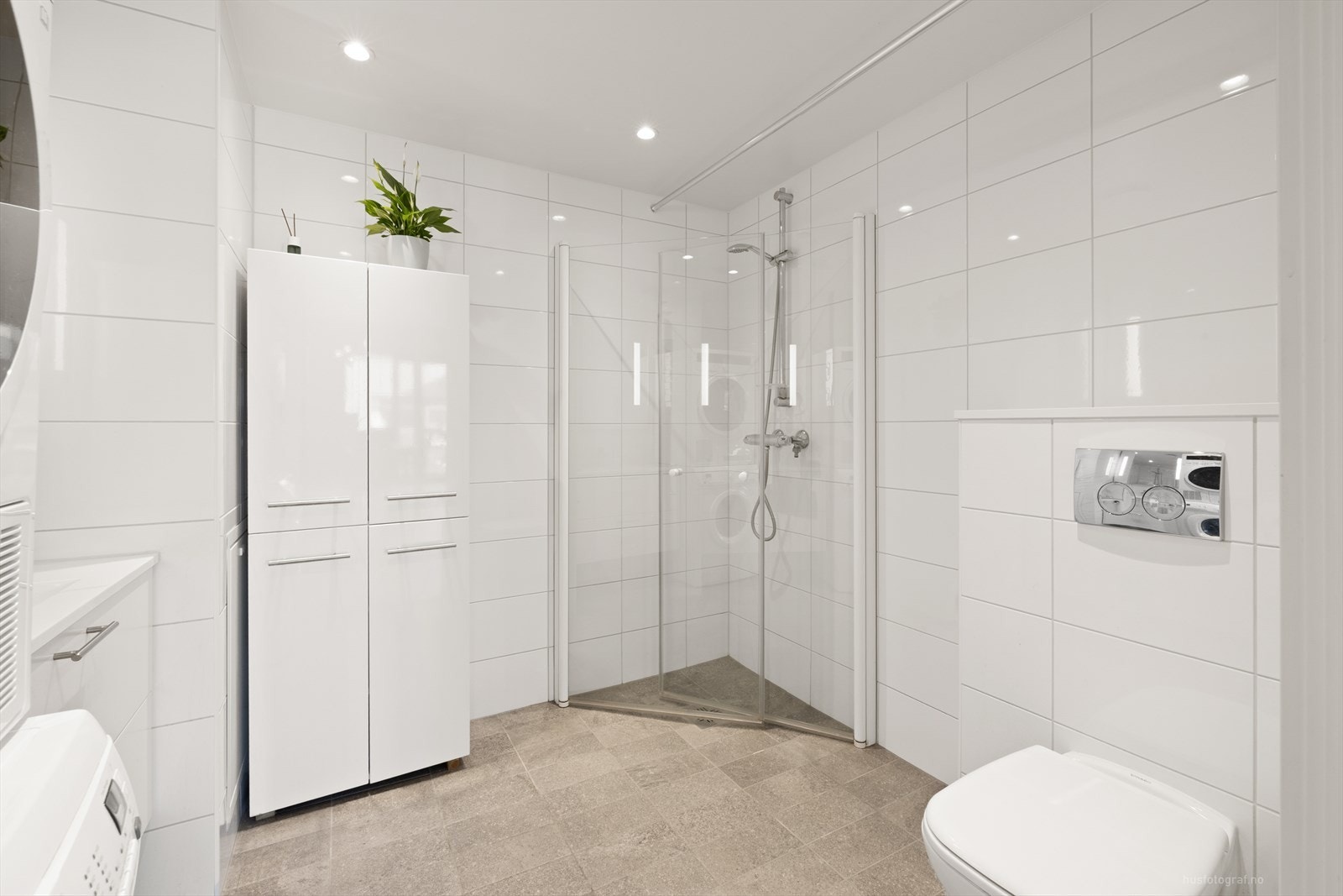 Pent og tidsriktig bad med flislagte overflater, varme i gulv og downlights i himling. Galleribilde