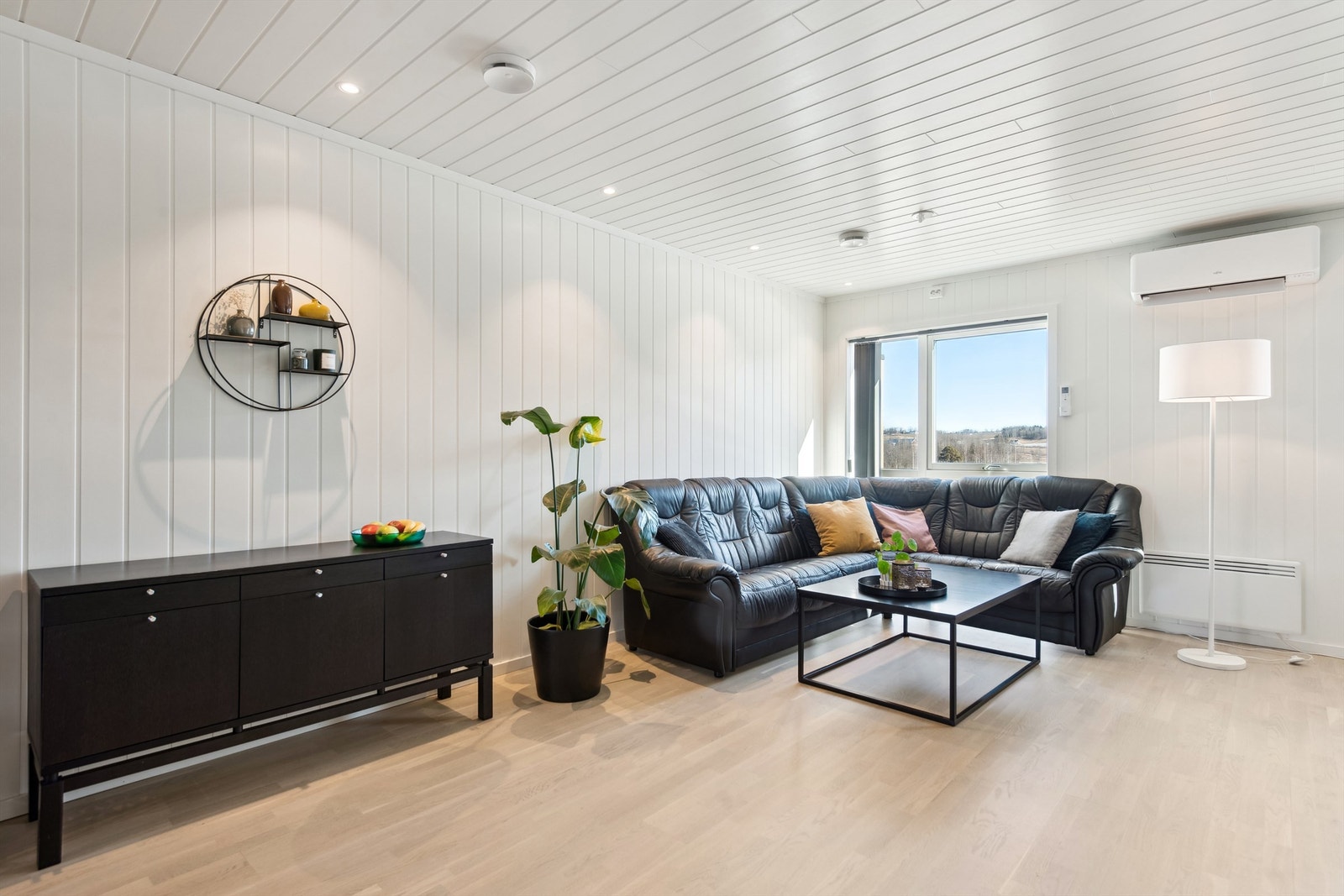 Stuen er lys og hyggelig og har utgang til terrasse Galleribilde