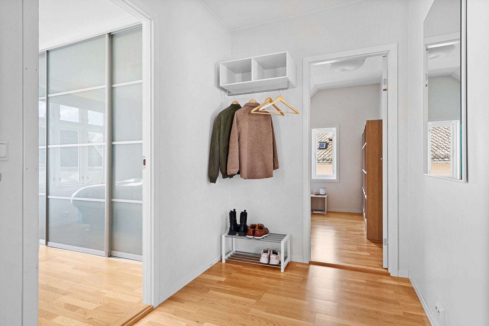 Entréen er lys med plass til å henge fra seg yttertøy og sko. Galleribilde