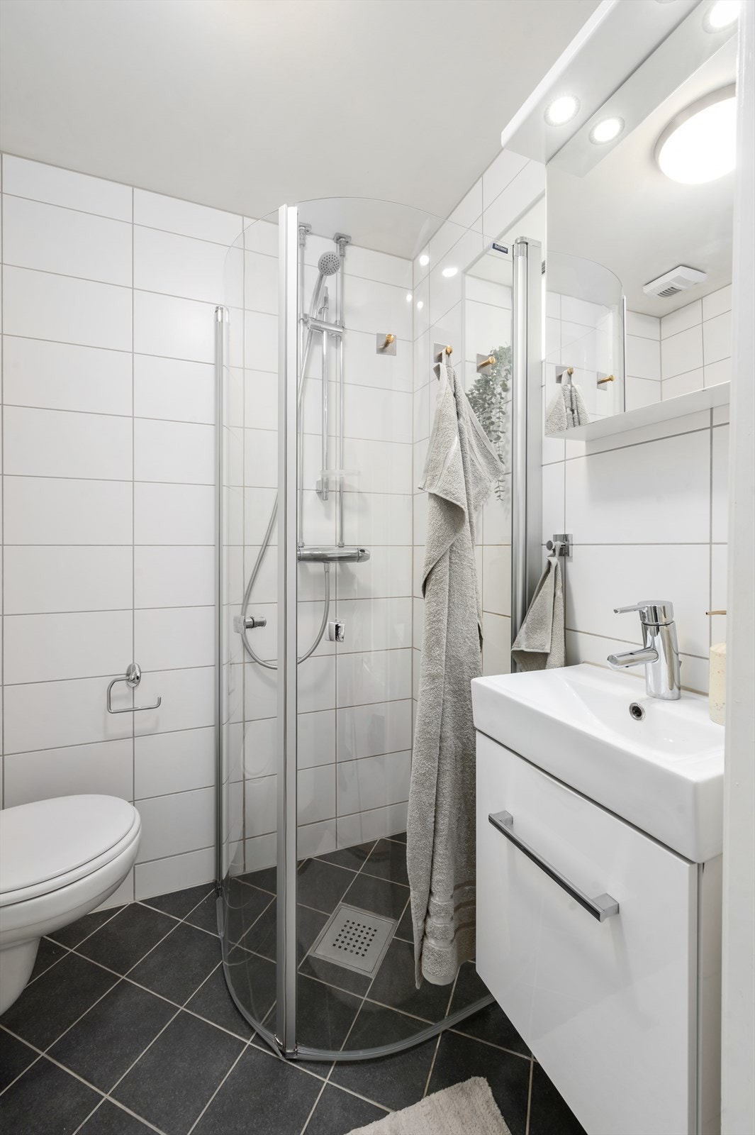 Videre har badet dusjhjørne med svingbare dører. Galleribilde