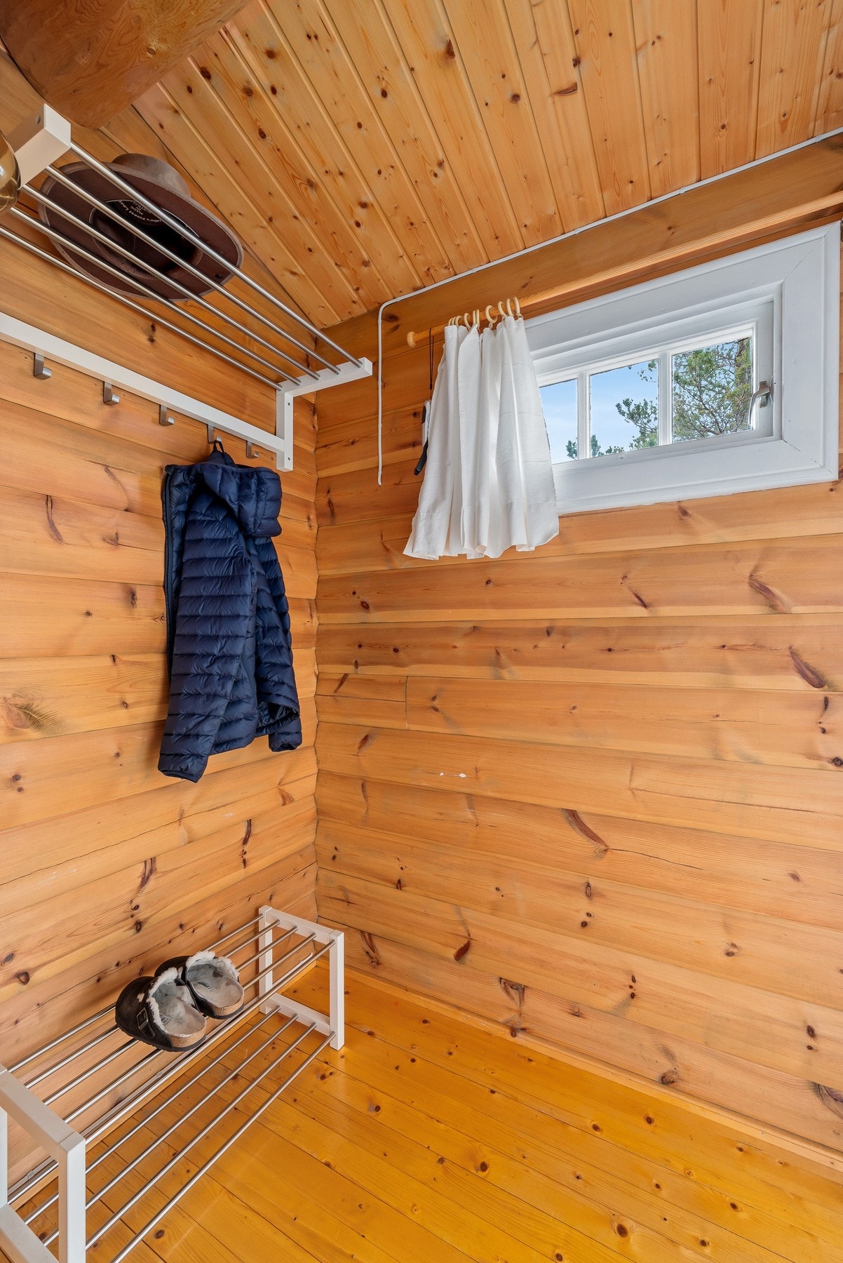 Vindfanget har åpen garderobeløsning og videre adkomst til stuen. Galleribilde