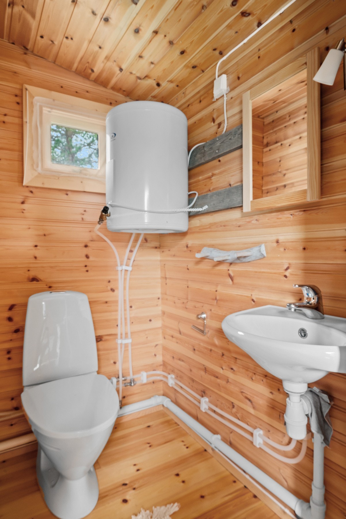 Toalettrommet er innredet med servant, toalett og en varmtvannsbereder fra 2016. Galleribilde