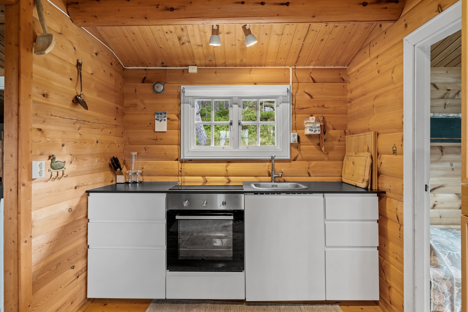 Kjøkkenet har vinduer på to sider, med innredning plassert under vinduet som vender mot skogen. Galleribilde