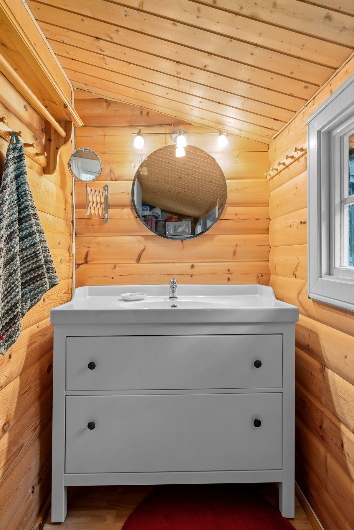 Et bodrom i hytta er innredet med servant, speil og belysning. Galleribilde