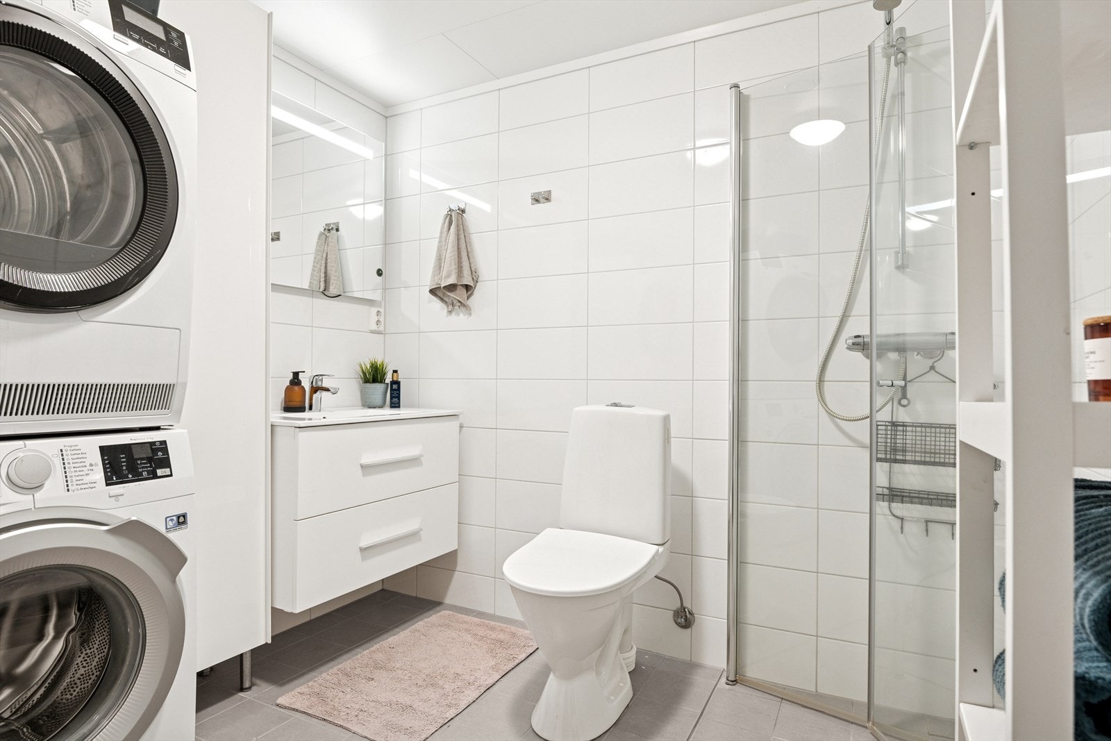 Lyst og flott bad med oppbevaring og opplegg for vaskemaskin. Galleribilde