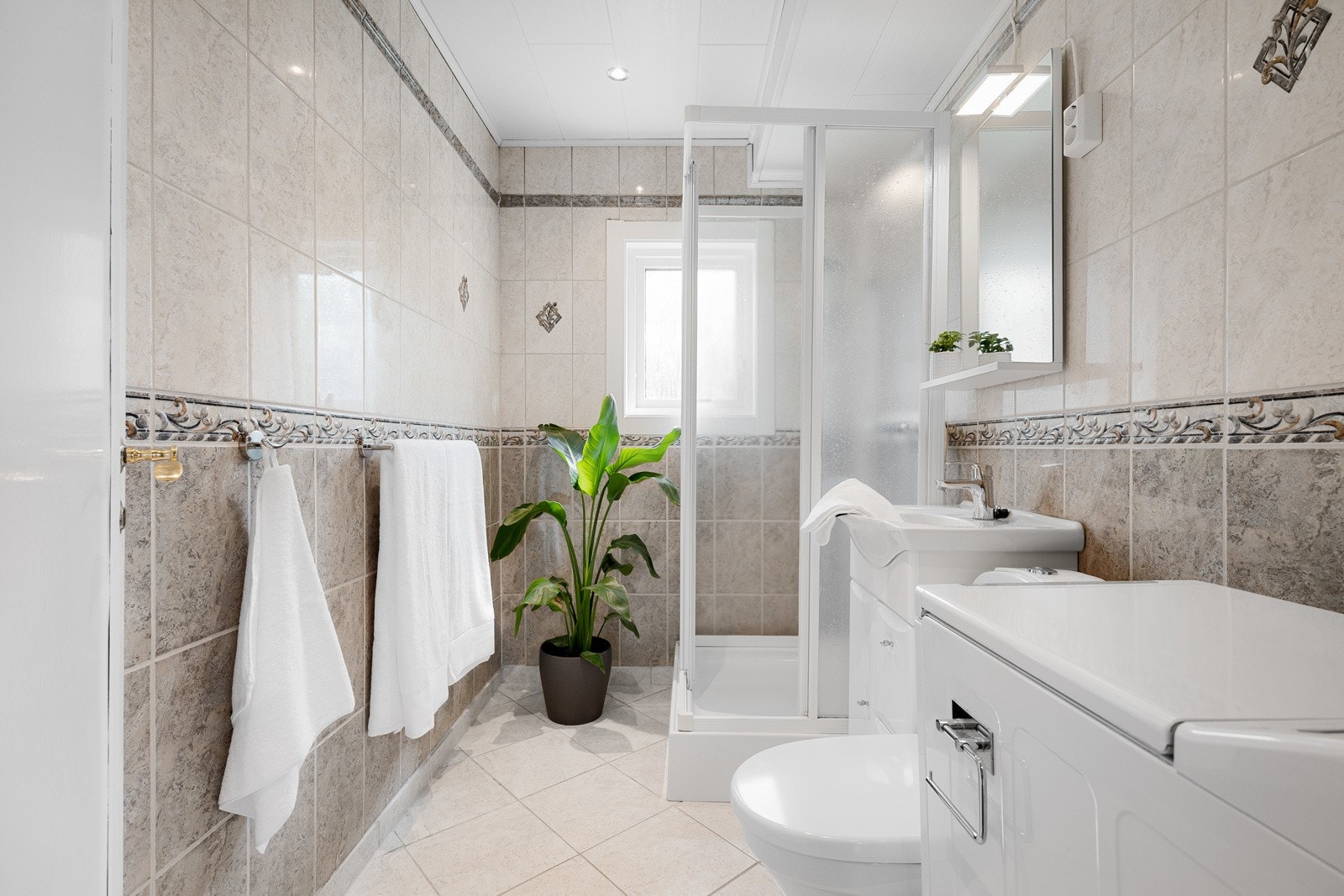 Flislagt baderom med gulvvarme og downlights. I 2025 ble det skiftet blandebatteri på vasken. Galleribilde