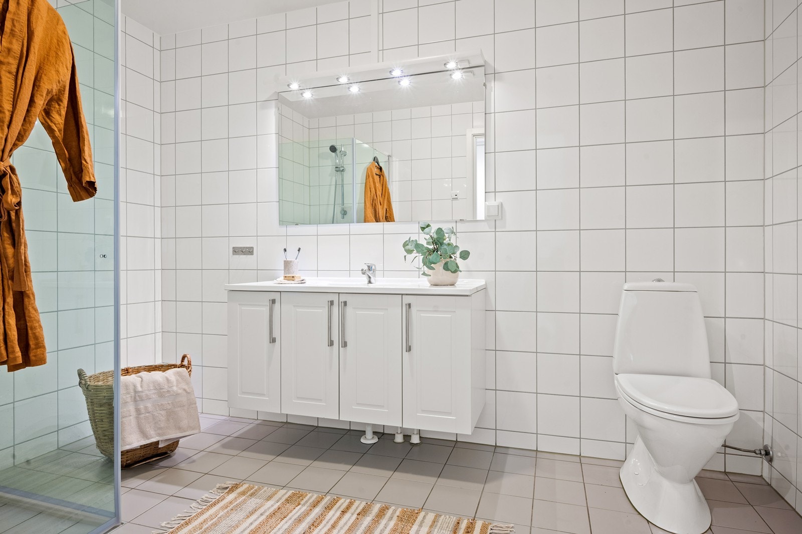 Romslig flislagt bad med varmekabel, det er separat vaskerom Galleribilde