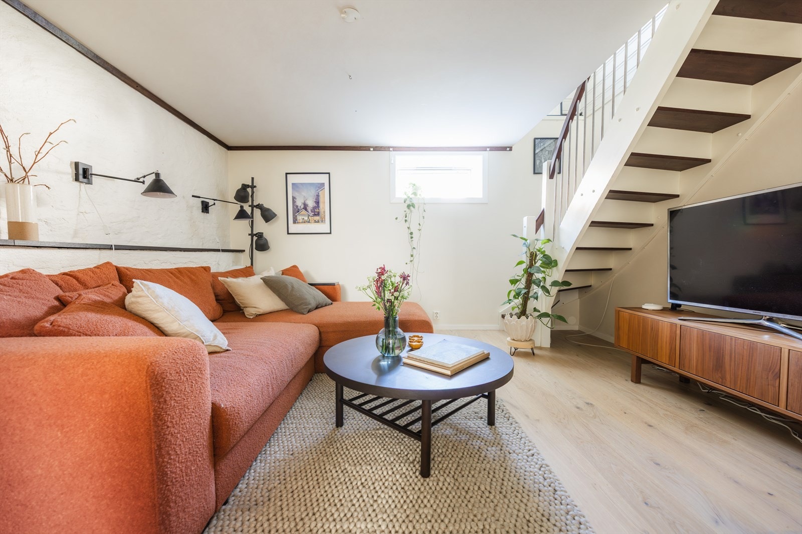 - Kjellerstuen er delt i soner med sofasone, tv-benk og hyggelig peis - Galleribilde