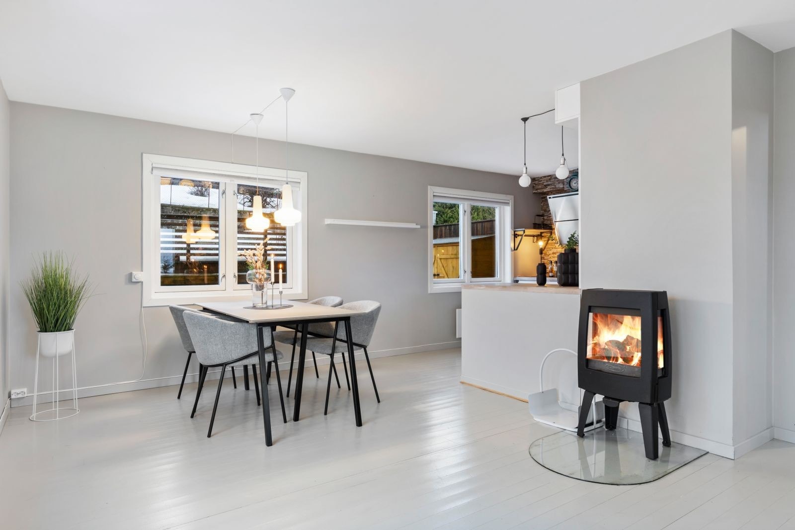 Spisestue og deler av kjøkkenet kan sees. Vedovn med tre glassfelt. Galleribilde