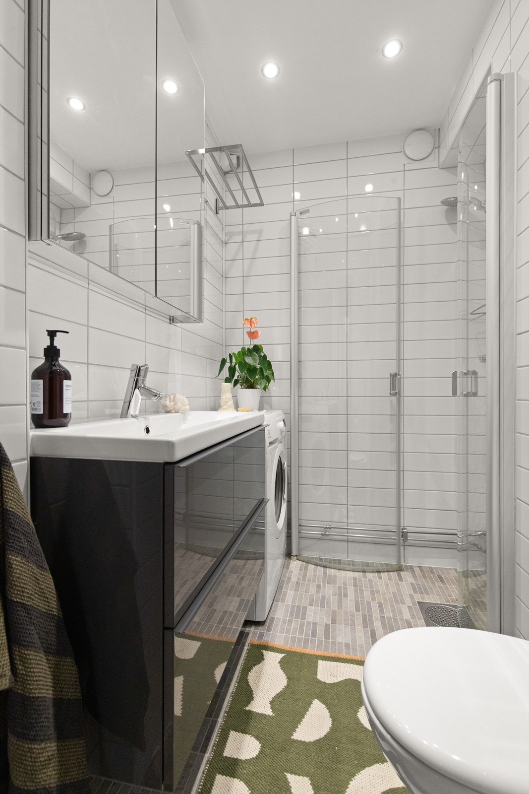 Badet er pent flislagt på gulv og vegger med varme i gulvet. Innredningen er fra IKEA og består av vegghengt servantinnredning med nedfelt servant. Galleribilde