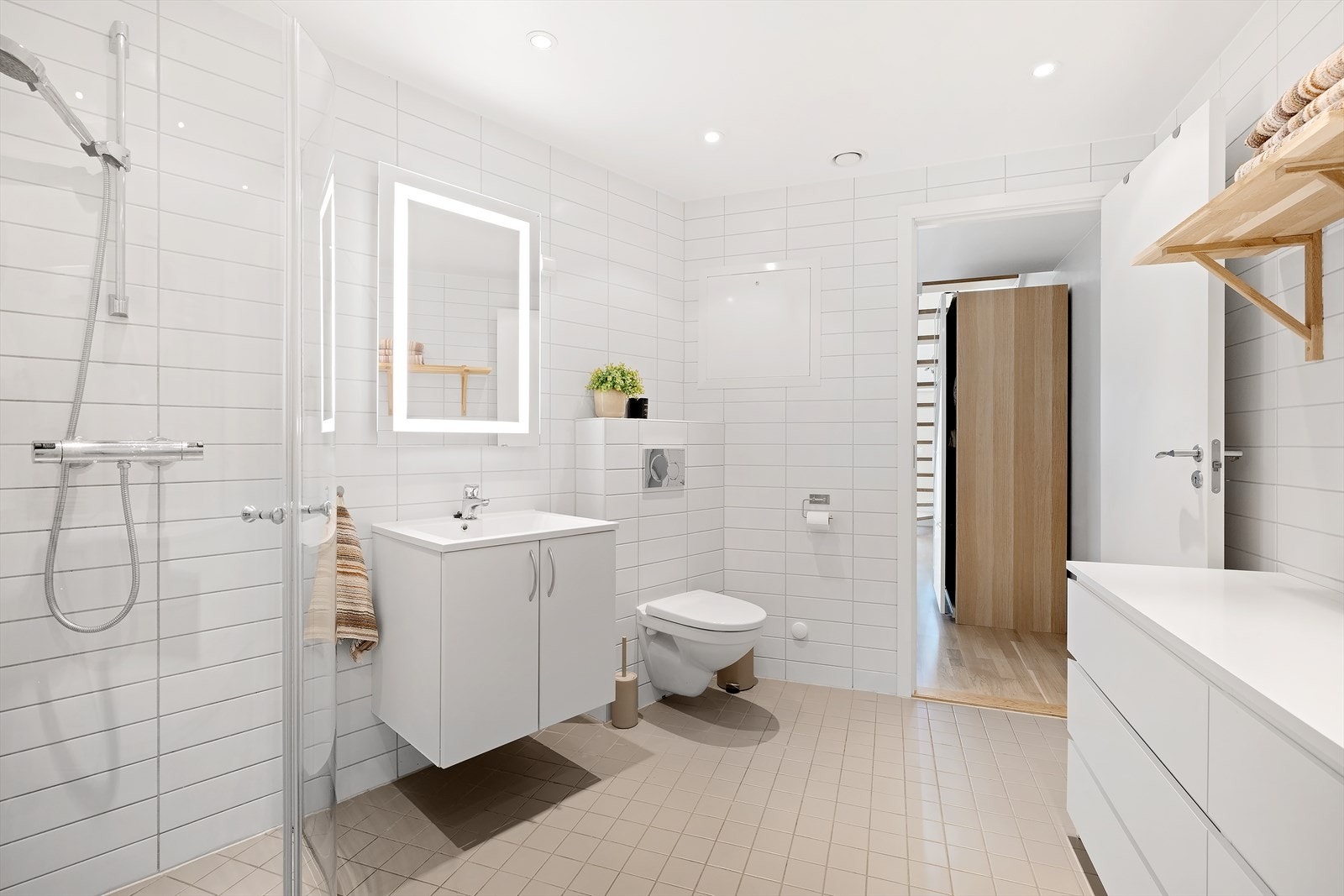 Innredningen består av vegghengt toalett, servant med hylleseksjoner, dusjnisje, vegghengt hylle og opplegg for vaskemaskin. Galleribilde