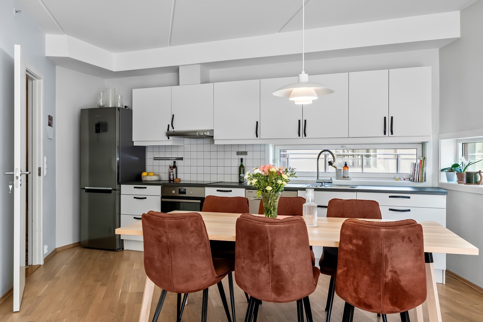 Stilrent og moderne kjøkken med svært praktisk utforming. Innredningen består av hvite, slette fronter og laminert benkeplate Galleribilde