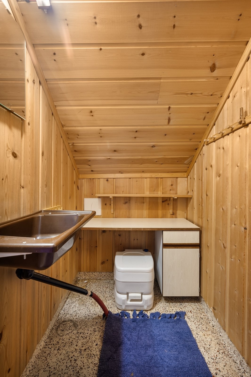 Rom i hytta med utslagsvask og bærbært enkelt toalett for vannlating f.eks. nattestid. Galleribilde