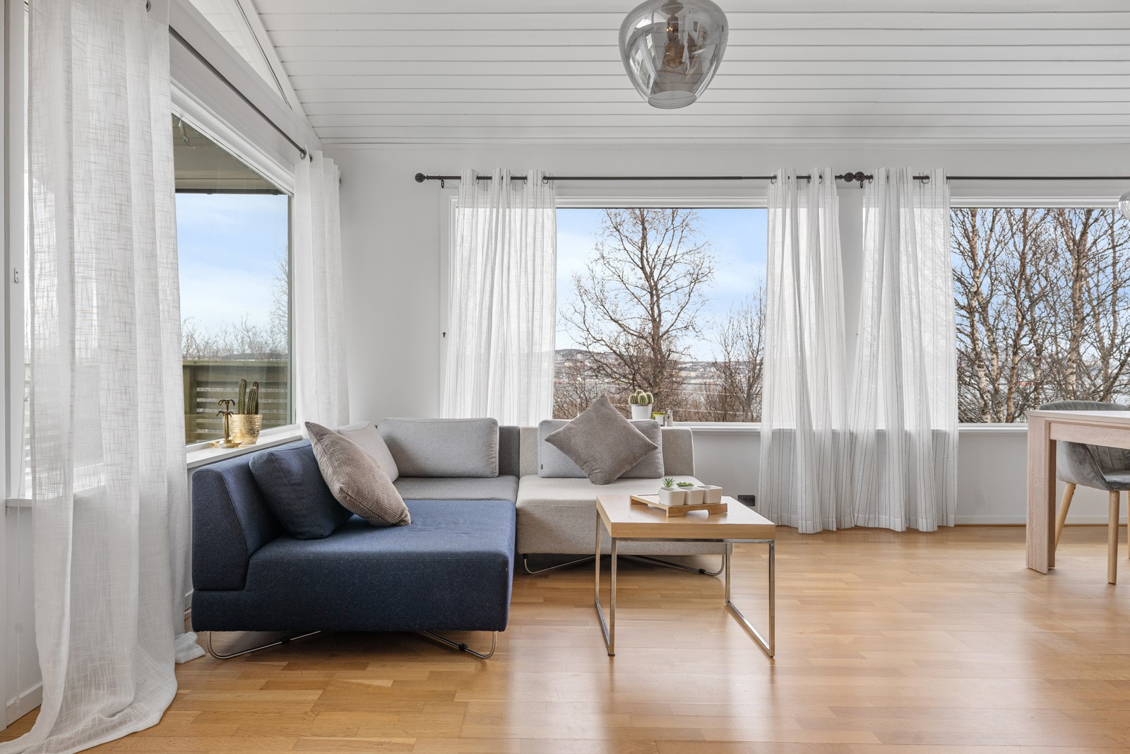 Store vinduer som sørger for godt med naturlig lysinnslipp, som gir rommet en lett og luftig følelse.