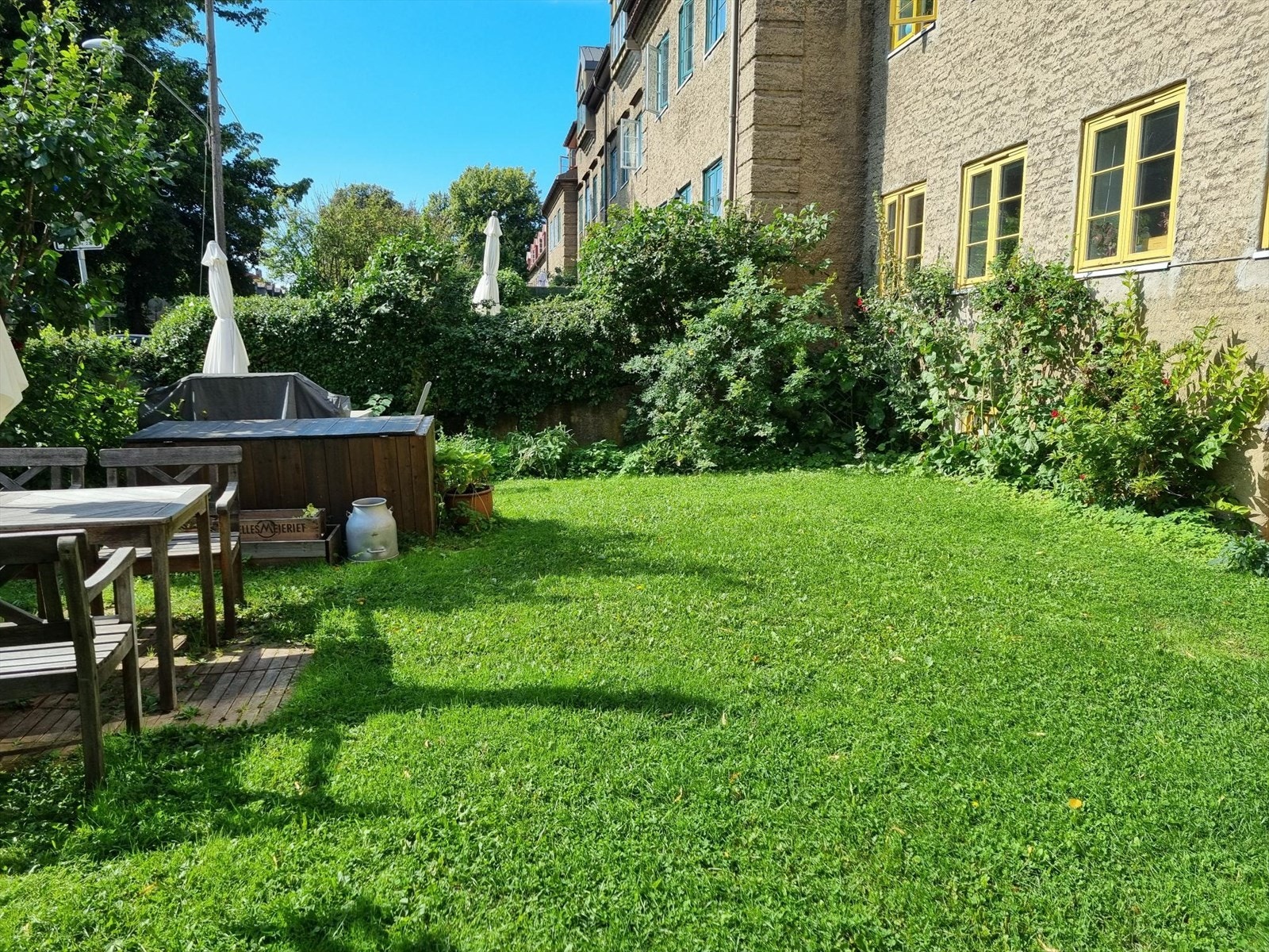 Den grønne plenen og den velholdte hagen gir et behagelig og privat uteområde, mens den vakre hekkingen gir et naturlig skjermet rom for å nyte utendørs. Galleribilde