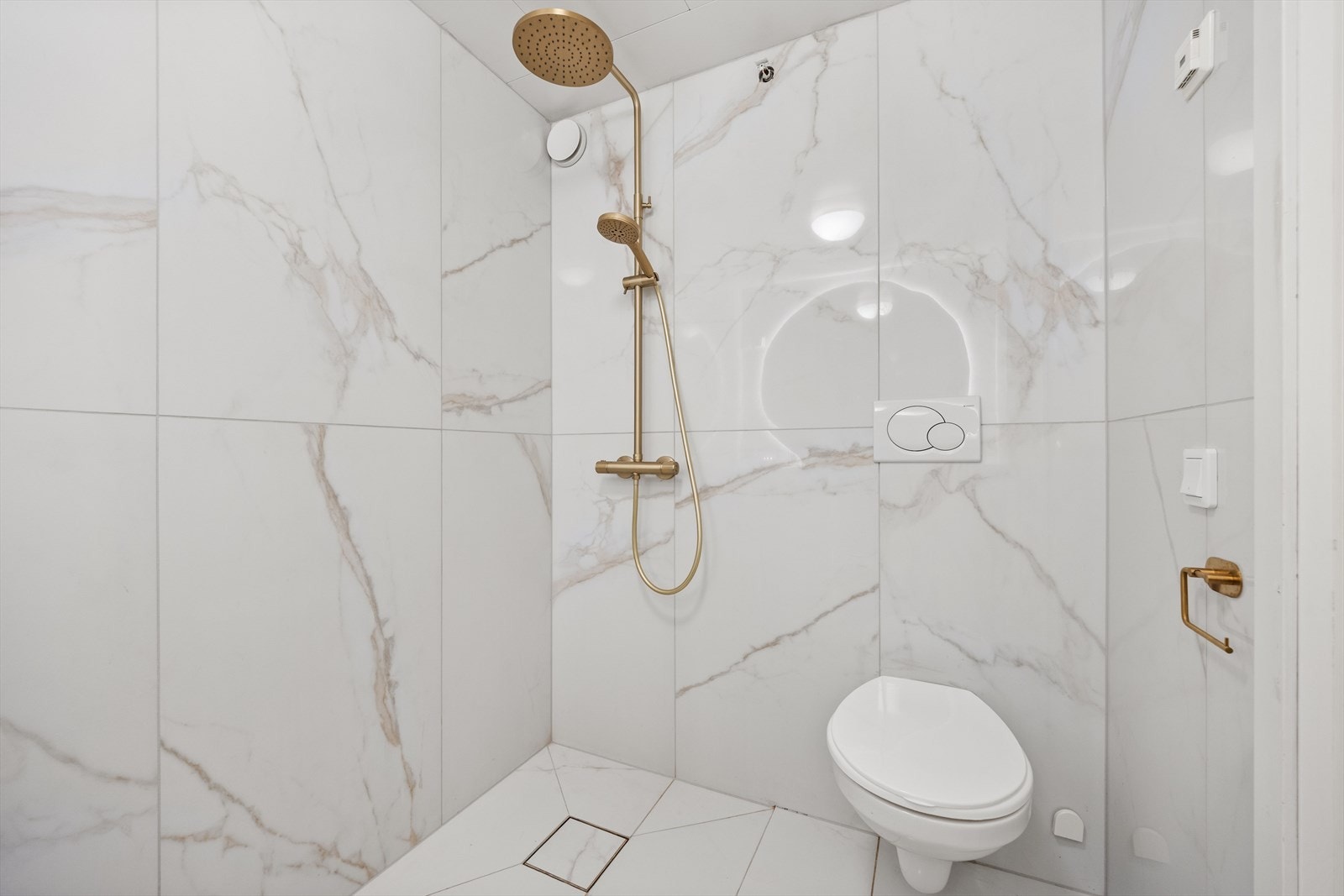 Badet er utstyrt med flislagt benk med servantbolle og hyller, speil med lys, dusjnisje m/regndusj, samt toalett Galleribilde