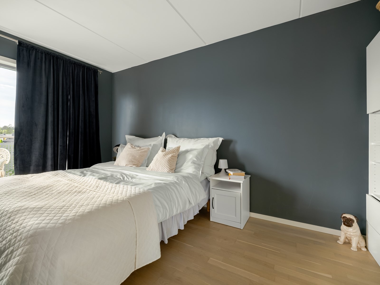 Rommet har god plass til dobbeltseng og nattbord på hver side, og langs den ene veggen er det montert en stor garderobe som både gir rikelig oppbevaring og ekstra romfølelse. Galleribilde