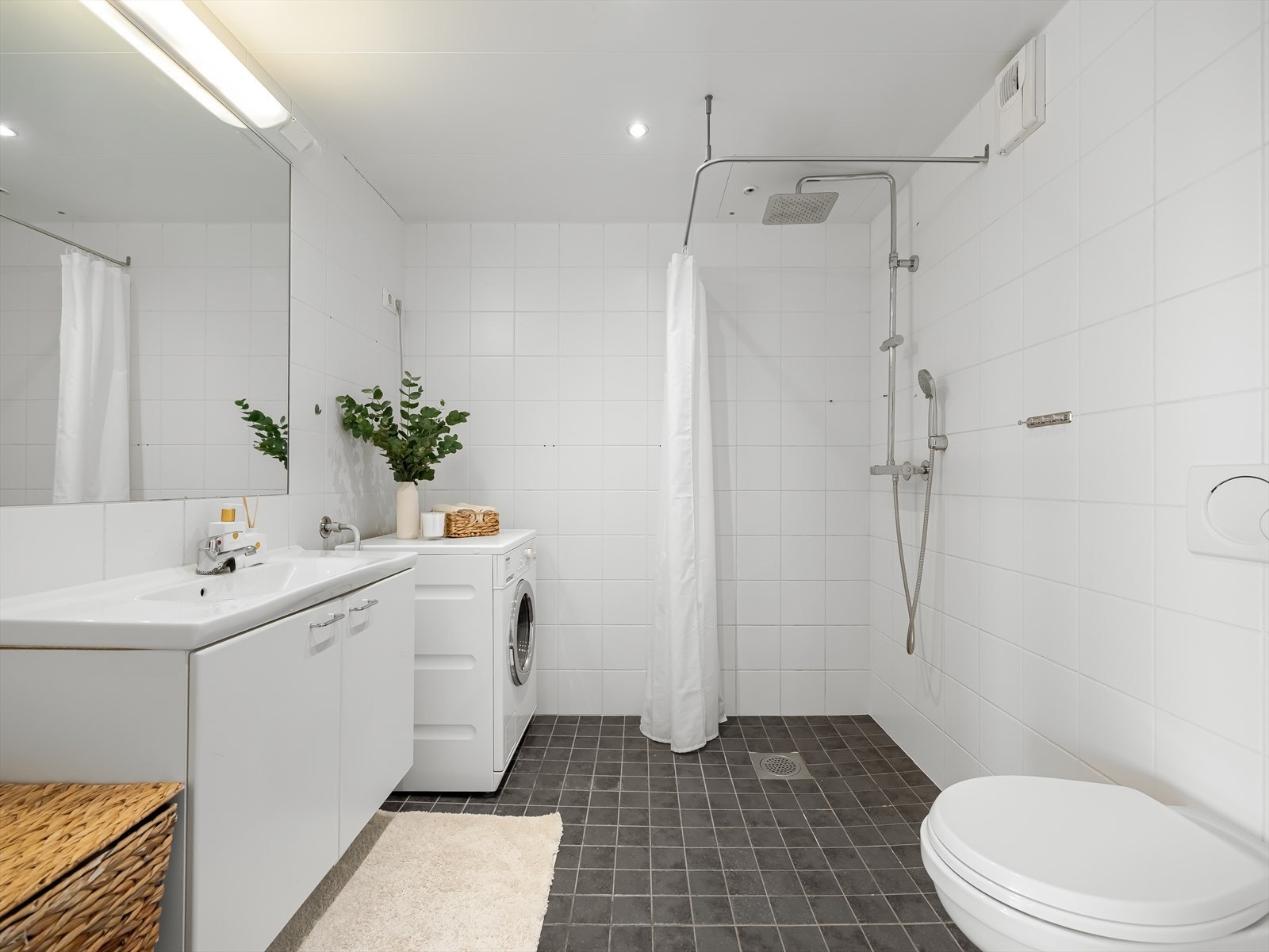 Lekkert bad med moderne overflater. Flislagte vegger og gulv med elektrisk gulvvarme gir et lunt og komfortabelt innemiljø. Himlingen har downlights. Galleribilde