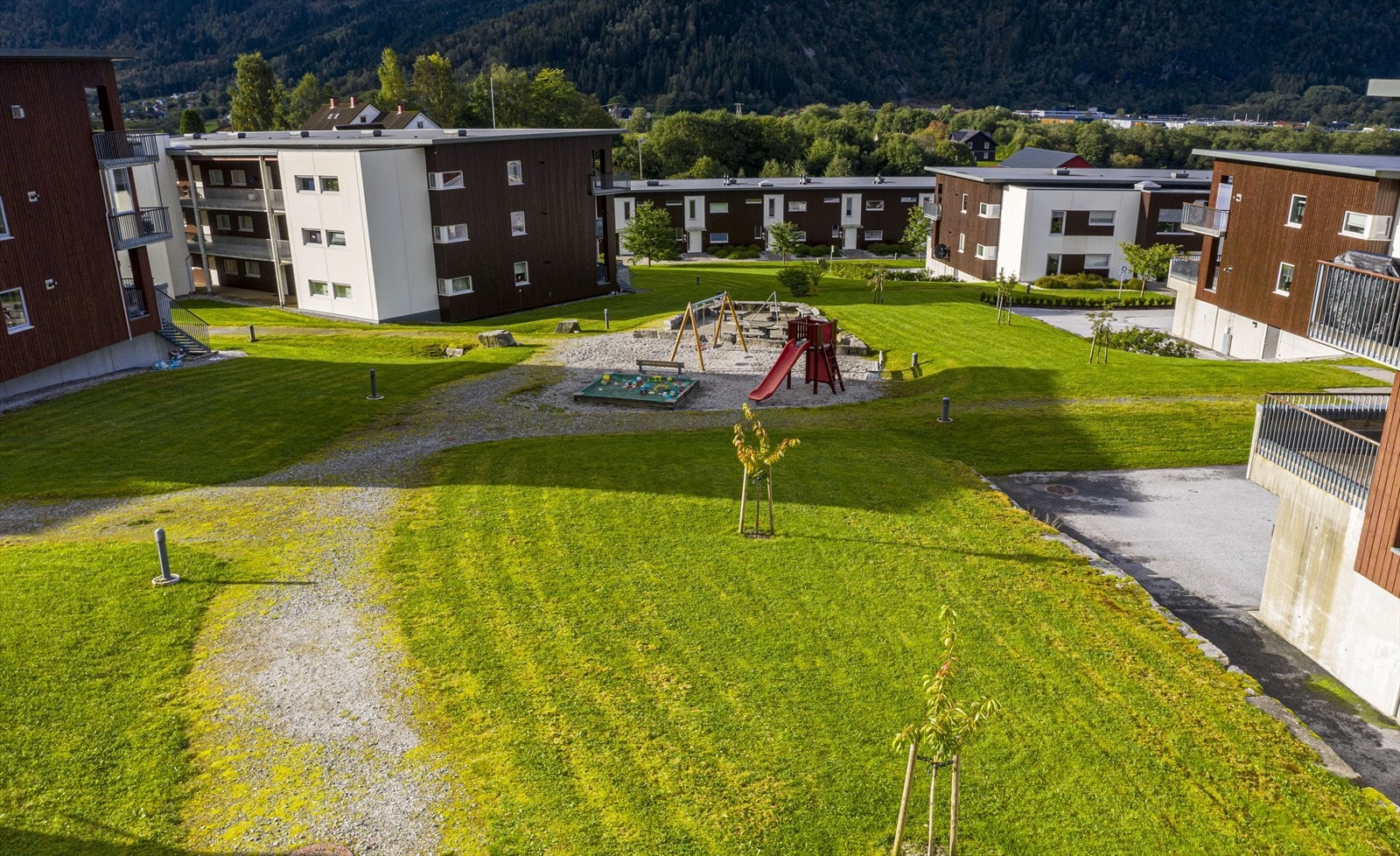 - Fellesarealene er pent opparbeidet med flotte grøntarealer, asfaltert vei og lekeplass - Galleribilde