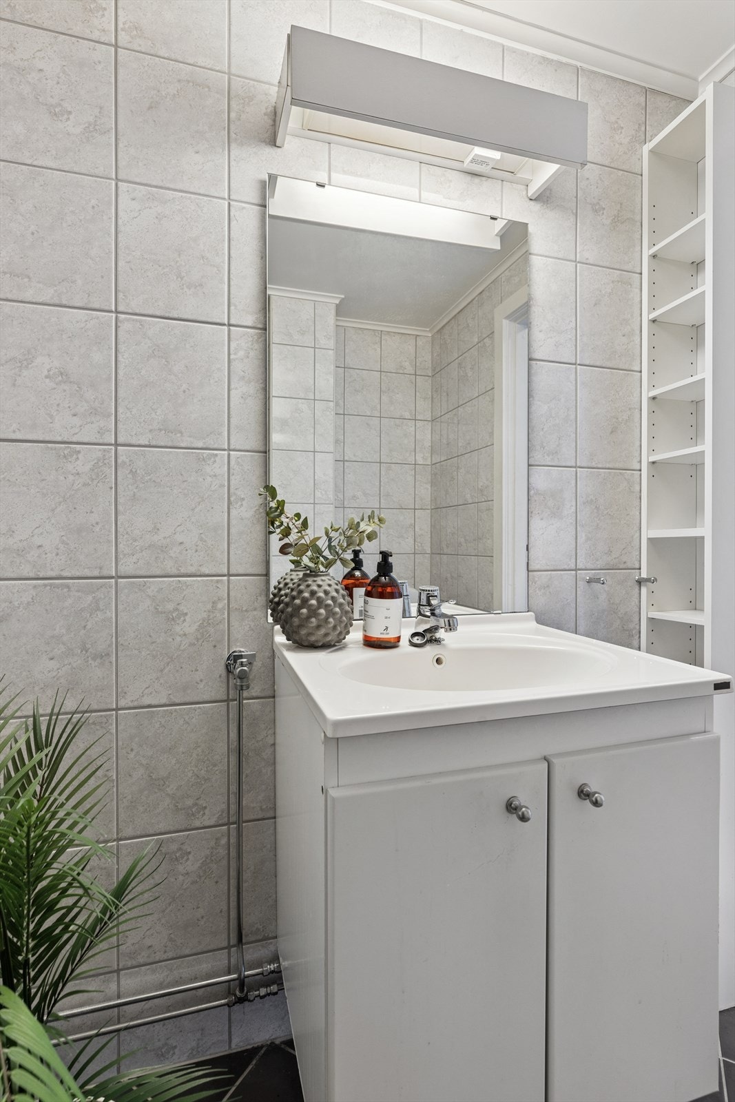 Termostatstyrte varmekabler, opplegg for vaskemaskin og god ventilasjon med naturlig avtrekk i himling. Servantskap med glatte fronter og gulvmontert toalett. Galleribilde